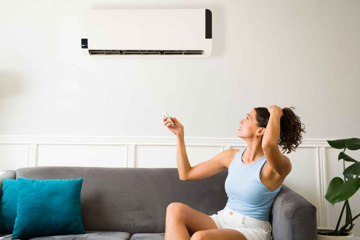 young woman feeling sweaty during a heat wave because her air conditioning is not working