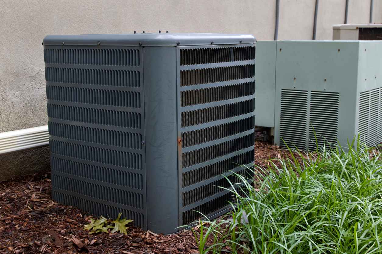 Air Conditioning units outdoors on side of apartment building.