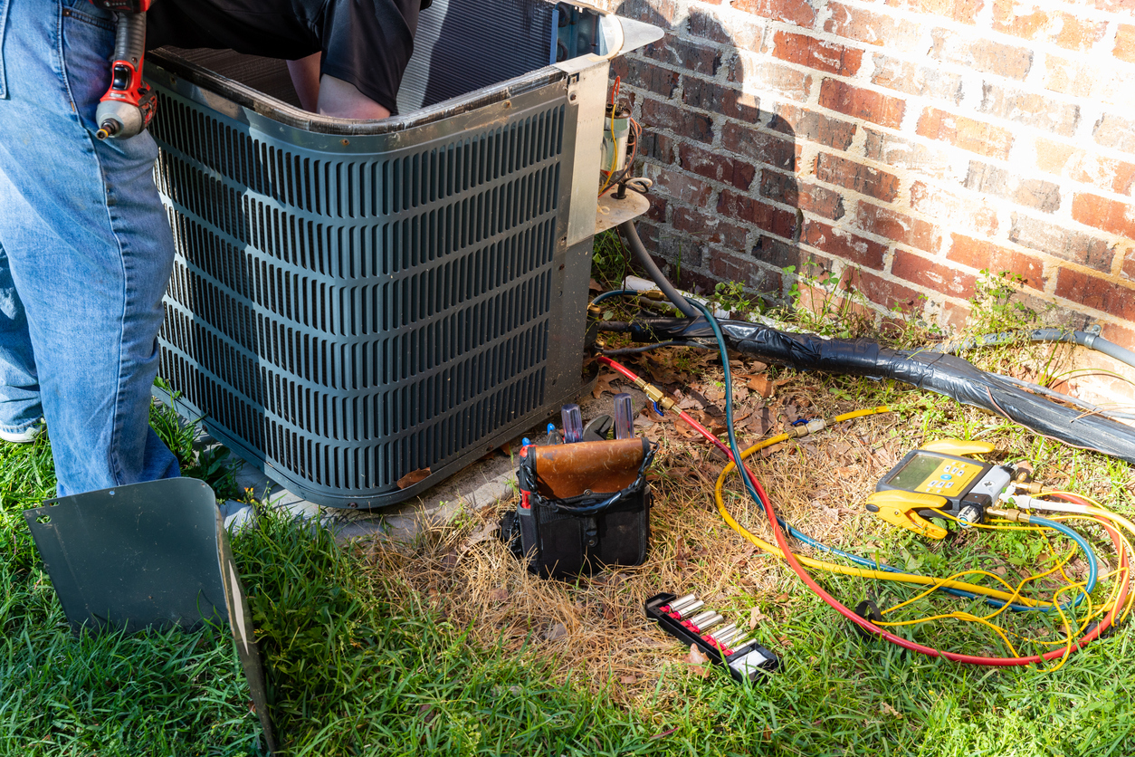 HVAC technician performing maintenance on outdoor unit